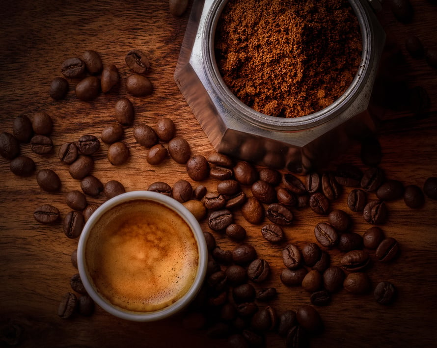 White Ceramic Mug Filled With Coffee Beside Coffee Beans